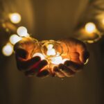 person holding string lights